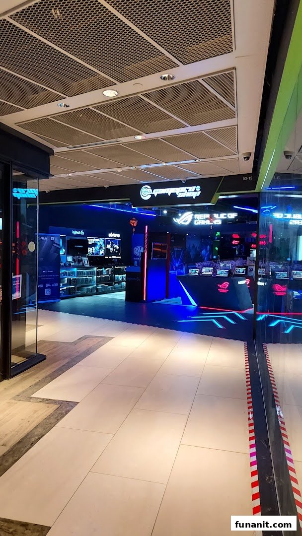 View of GAMEPROSG shop entrance, featuring vibrant blue lighting and gaming product displays.