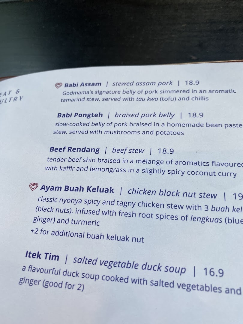 A close-up view of a menu page featuring traditional Peranakan main courses and their descriptions.