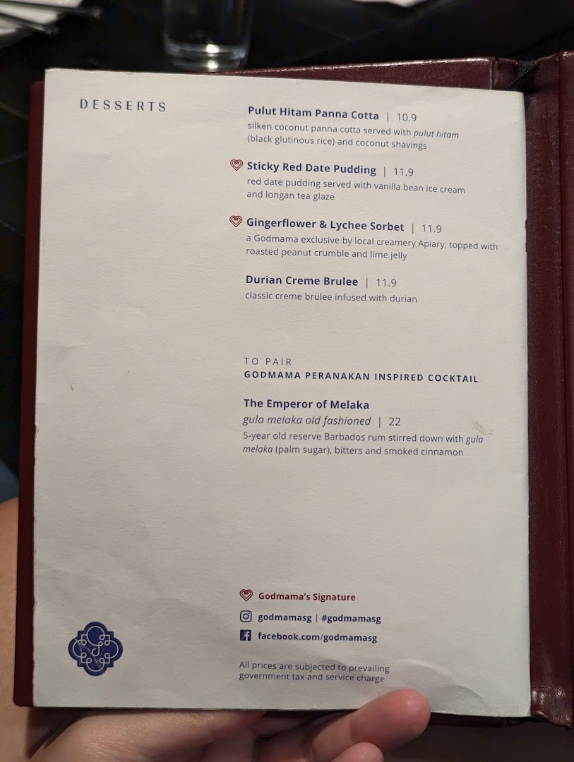 A close-up of Godmama's menu, featuring Peranakan-inspired desserts and a signature cocktail.