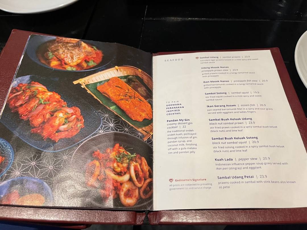 An open menu displaying various Peranakan seafood dishes and a cocktail.
