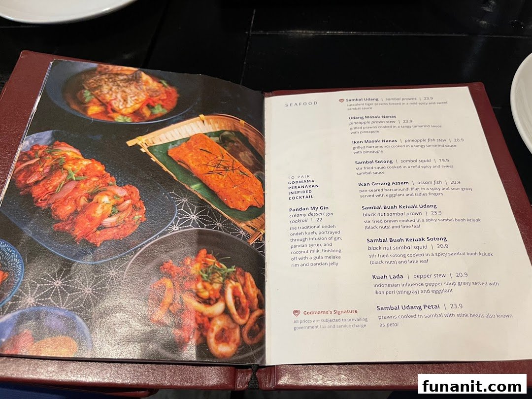 An open menu displaying various Peranakan seafood dishes and a cocktail.