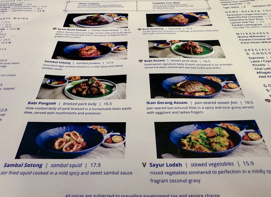 A detailed menu page from Godmama restaurant, showcasing various Peranakan main dishes with descriptions and prices.