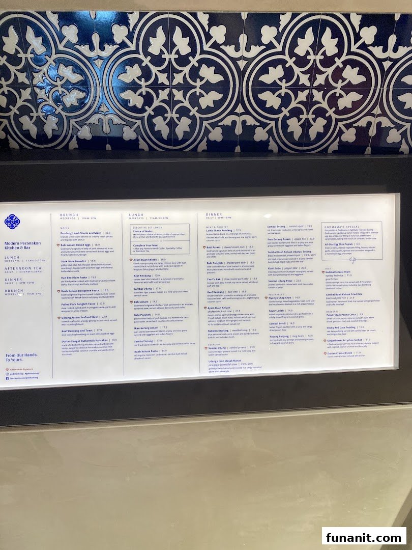 A detailed menu board for Godmama, a Modern Peranakan Restaurant, showcasing brunch, lunch, and dinner offerings.