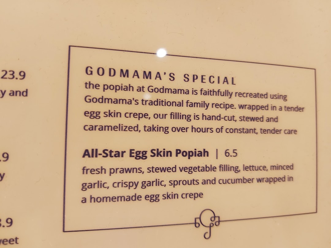 A close-up of Godmama's menu, highlighting their signature All-Star Egg Skin Popiah and its description.