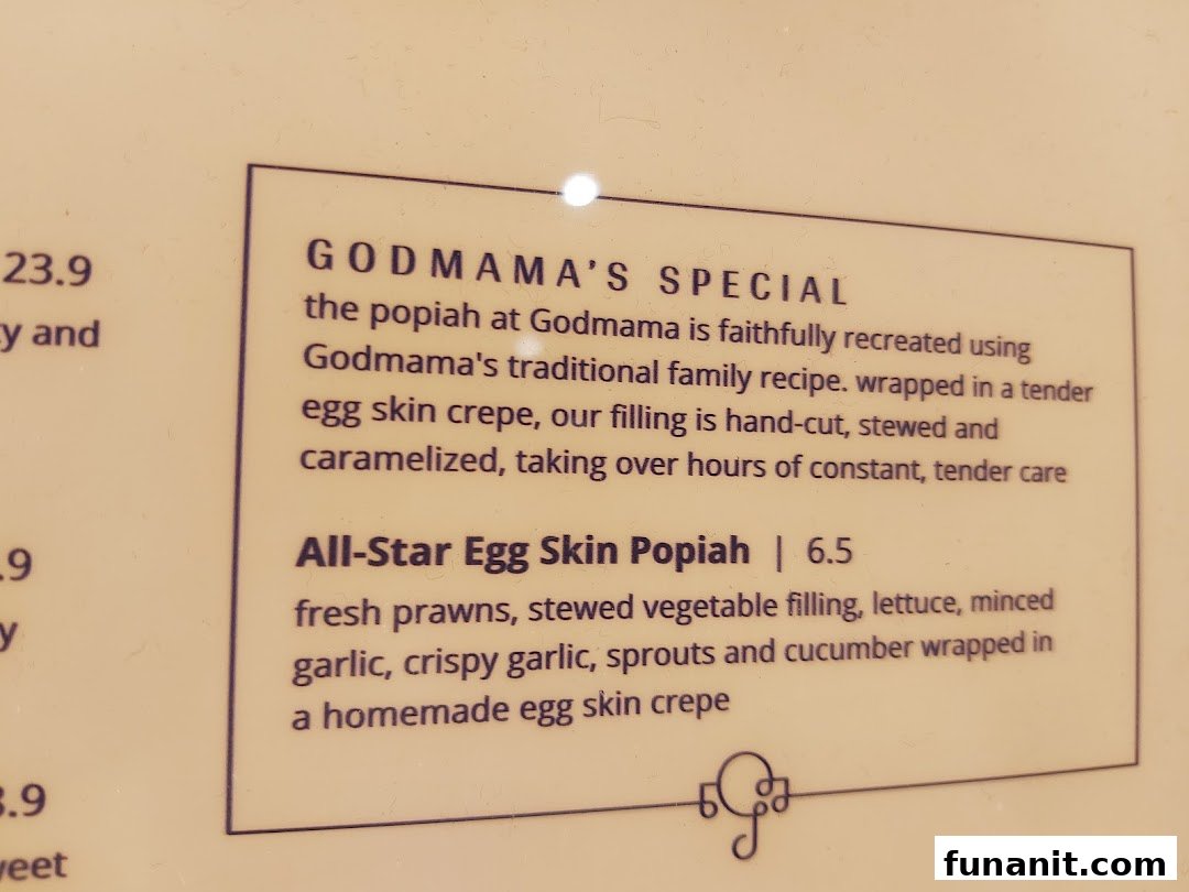 A close-up of Godmama's menu, highlighting their signature All-Star Egg Skin Popiah and its description.