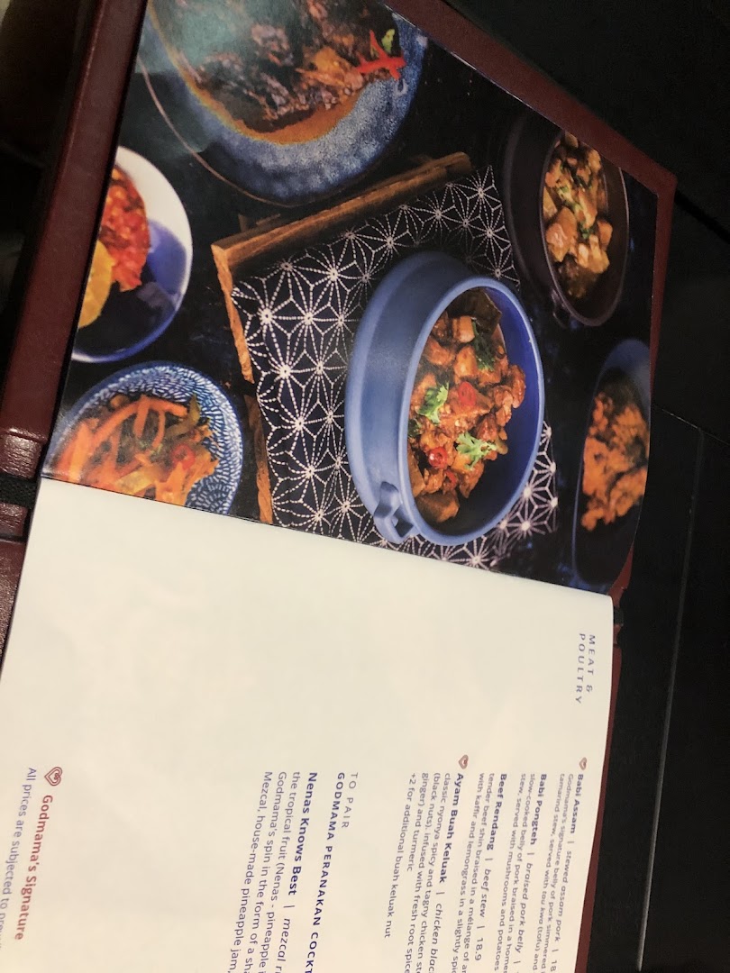 A vibrant menu page from Godmama restaurant, showcasing Peranakan dishes and cocktails with enticing food photography.