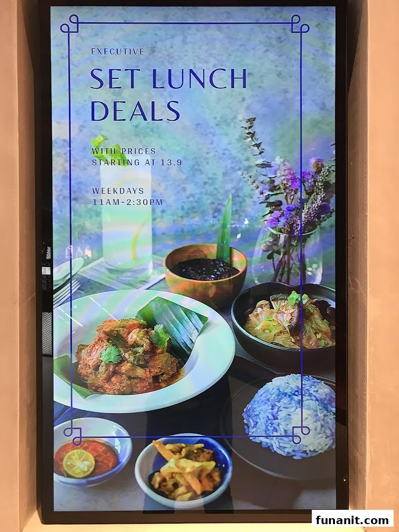A digital display showcasing Godmama's Executive Set Lunch Deals with vibrant Peranakan dishes.
