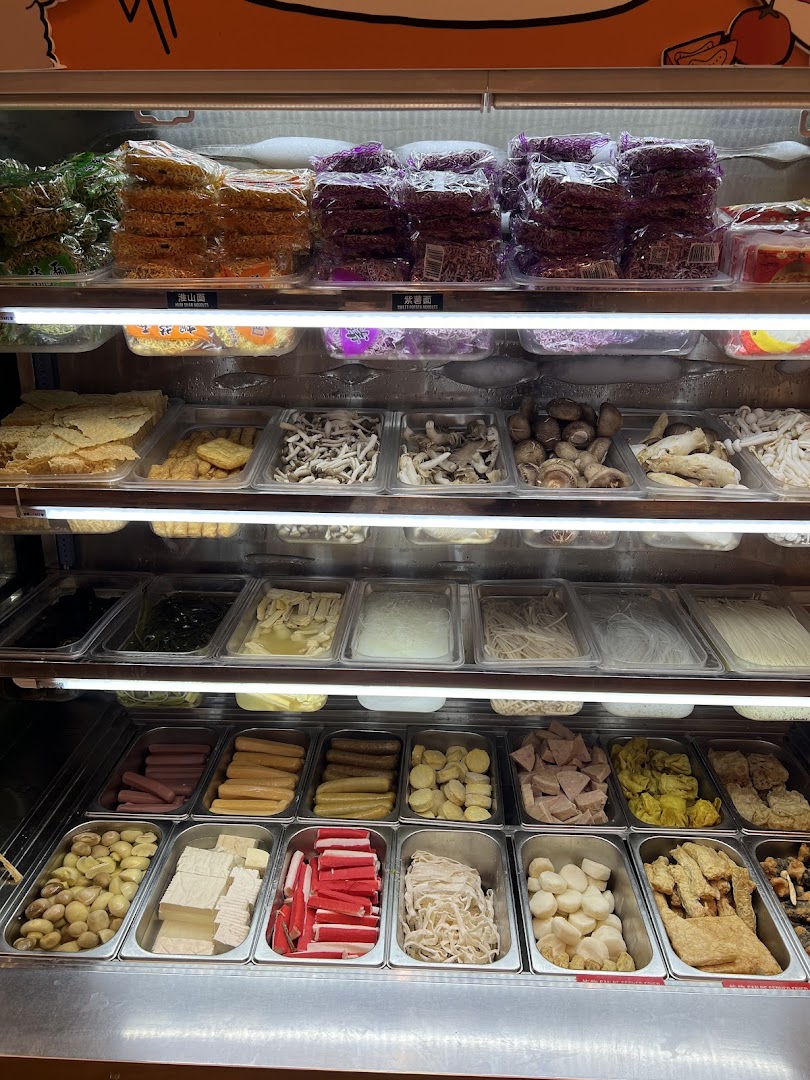 A vibrant refrigerated display showcasing a wide variety of fresh ingredients for custom mala tang dishes.
