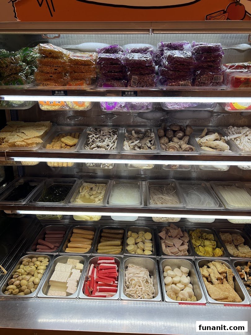 A vibrant refrigerated display showcasing a wide variety of fresh ingredients for custom mala tang dishes.