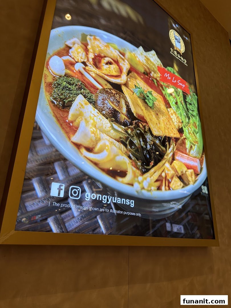 A vibrant backlit display showcasing a delicious bowl of Ma La Soup with various ingredients.