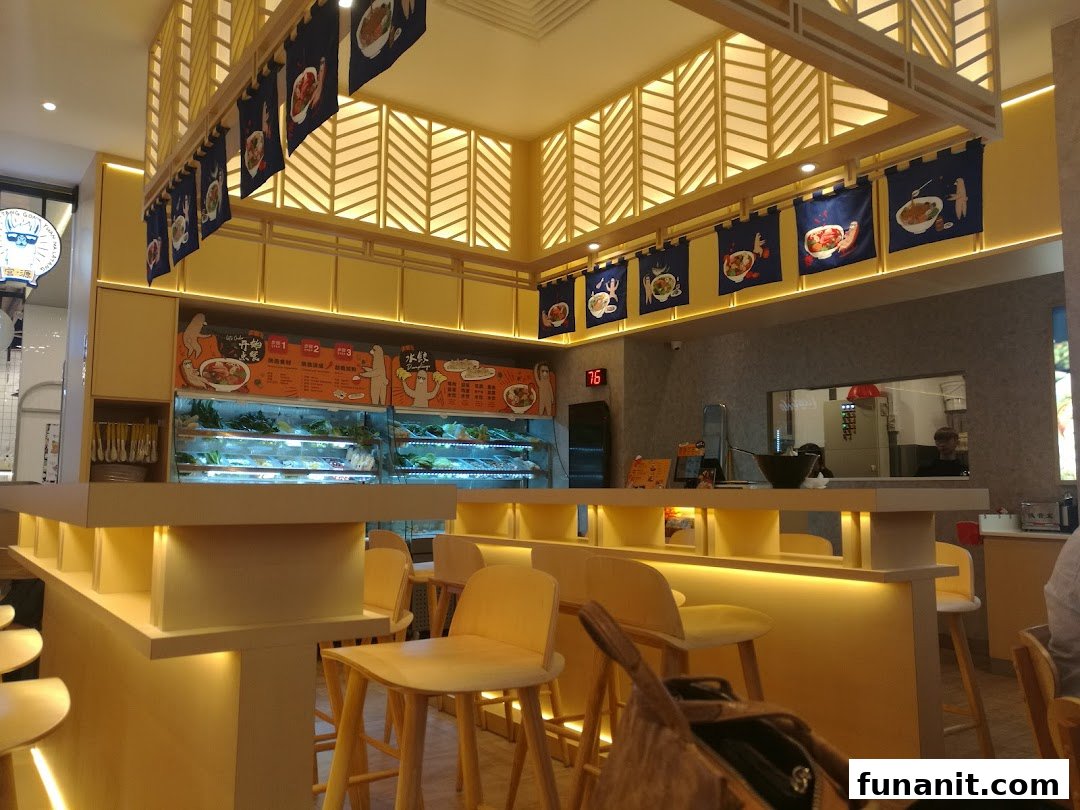Interior view of Gong Yuan Ma La Tang, featuring a bright, modern counter with ingredient displays and bar seating.