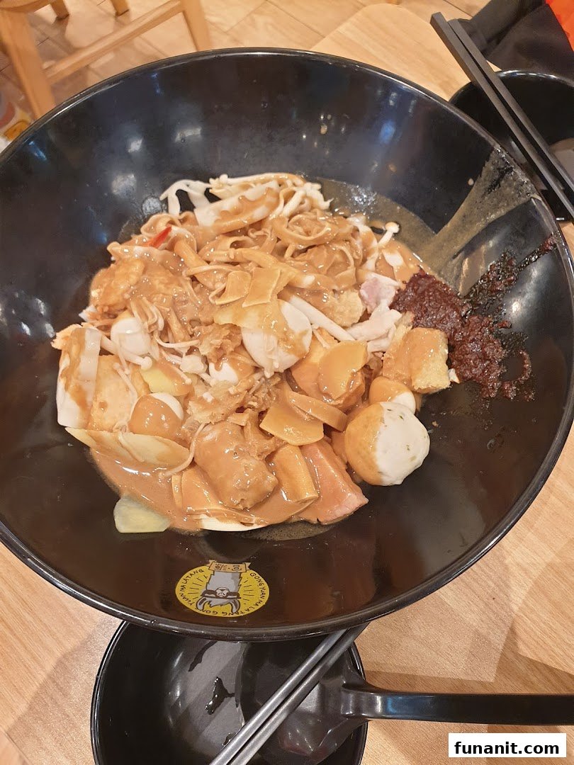 A close-up of a large bowl of customizable Mala Tang with various ingredients and rich sauce.