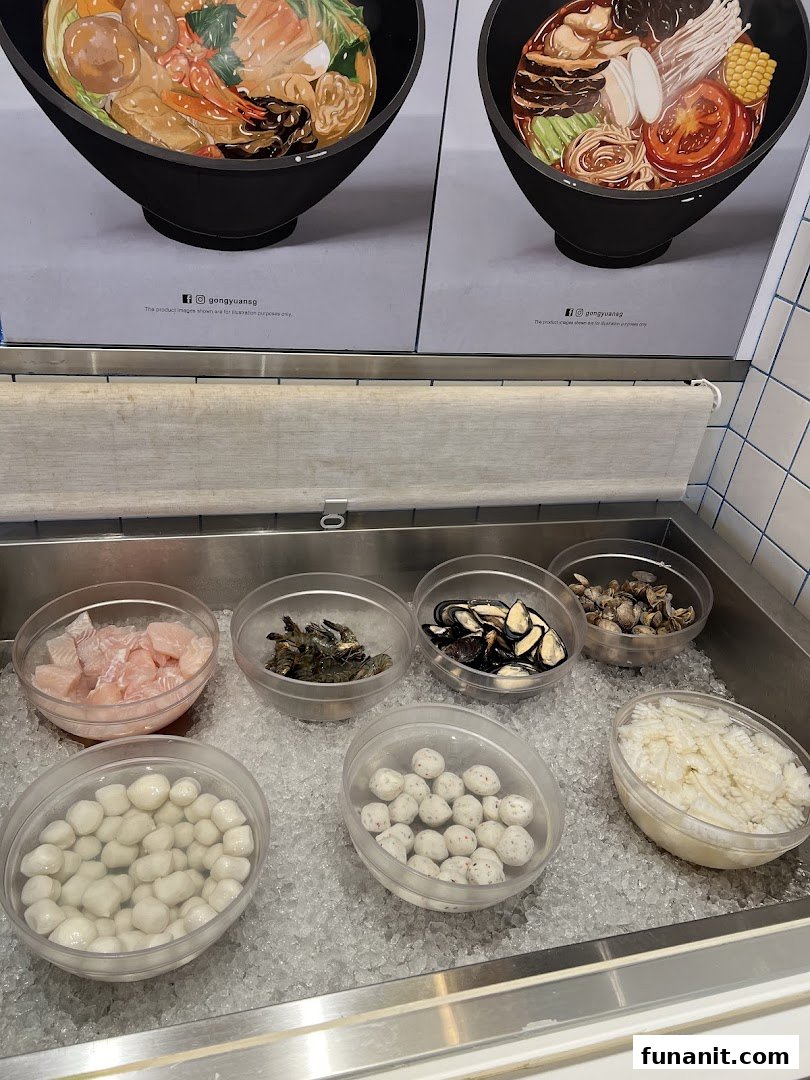 A vibrant display of fresh ingredients like seafood, fish balls, and vegetables on ice for Mala Tang.