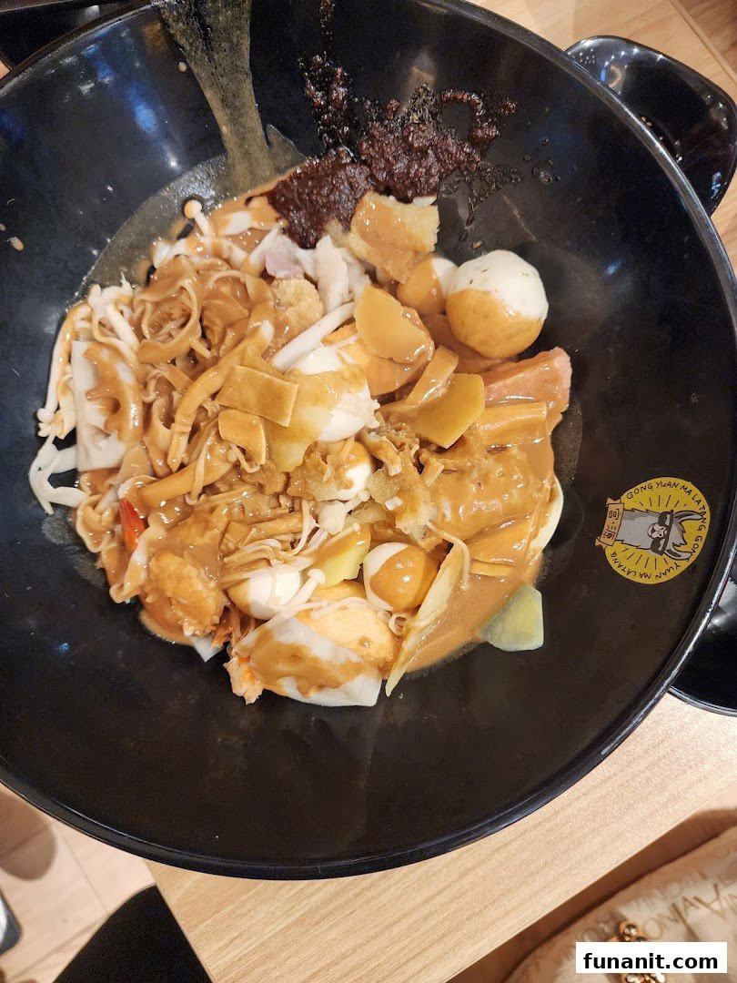 A close-up of a delicious bowl of Mala Tang with various ingredients and rich sauce.