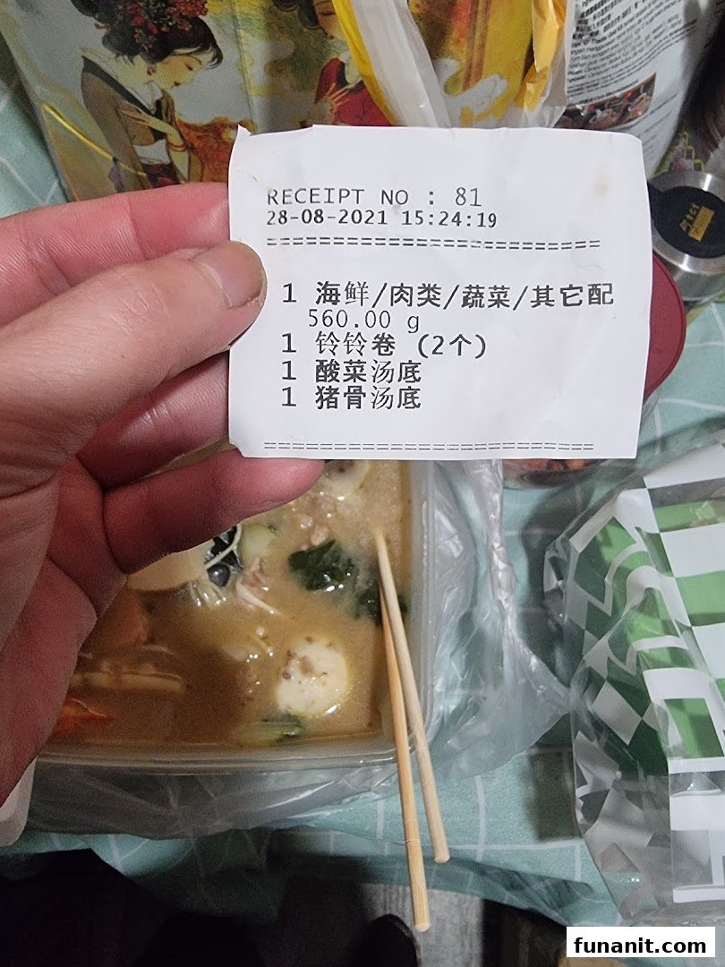 A hand holds a receipt detailing a Mala Tang order, with the customizable dish visible below.