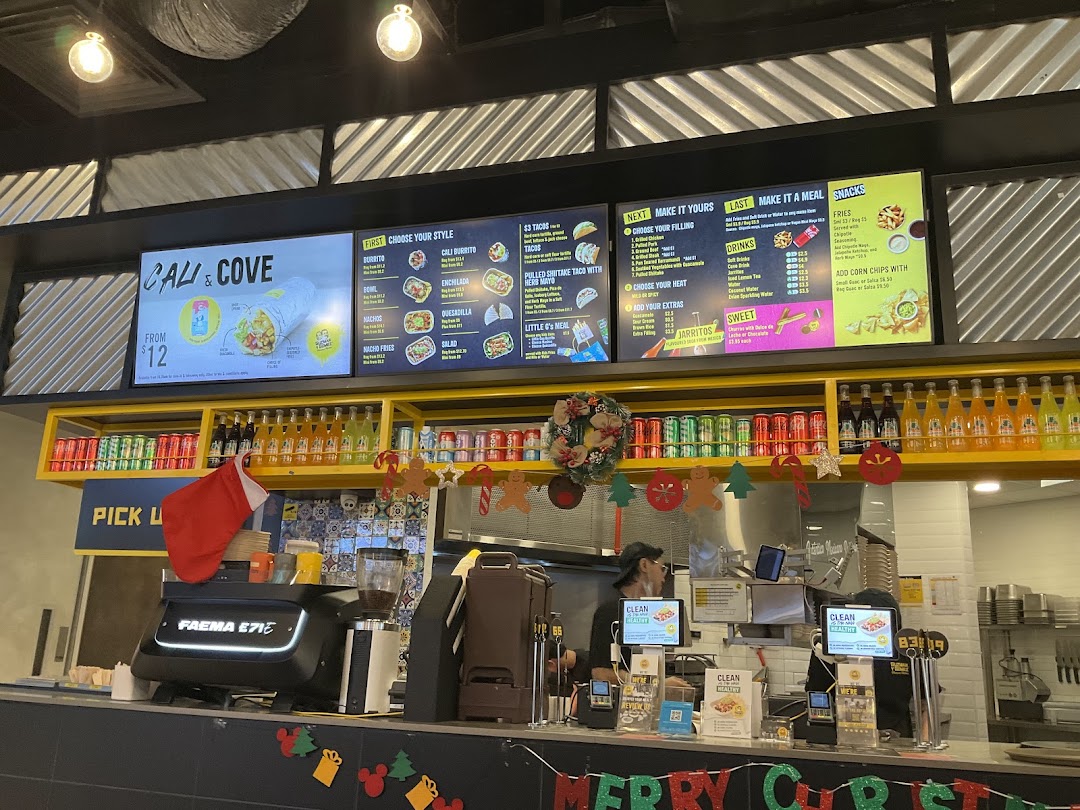 Interior view of Guzman y Gomez featuring digital menu boards, a service counter, and festive decorations.