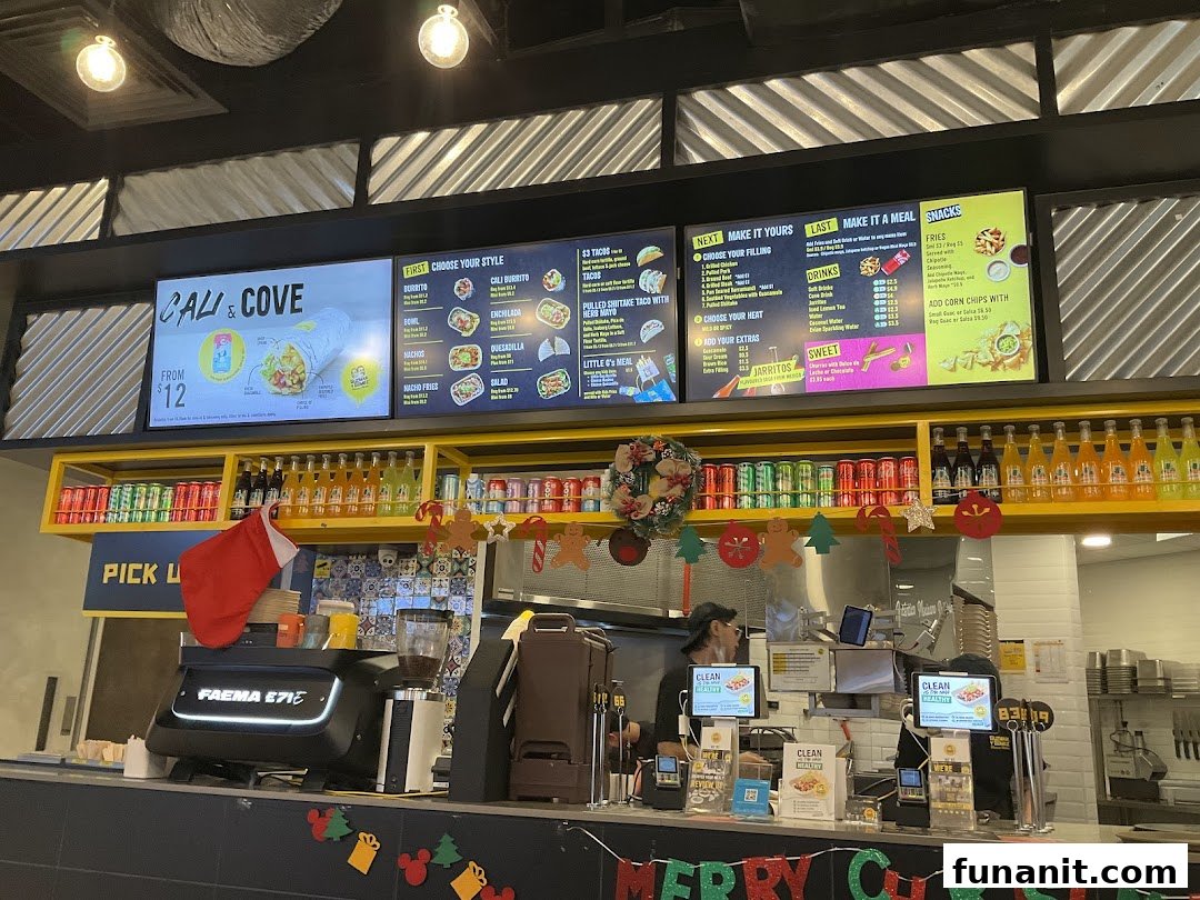 Interior view of Guzman y Gomez featuring digital menu boards, a service counter, and festive decorations.
