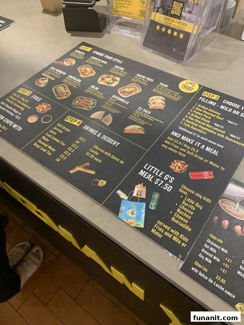 A detailed menu board displaying food and drink options at Guzman y Gomez.