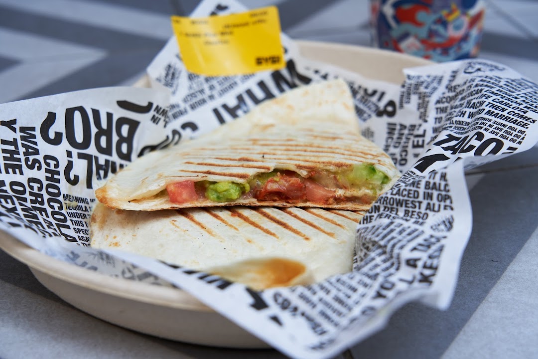 A close-up of a delicious quesadilla filled with fresh guacamole and tomatoes from Guzman y Gomez.