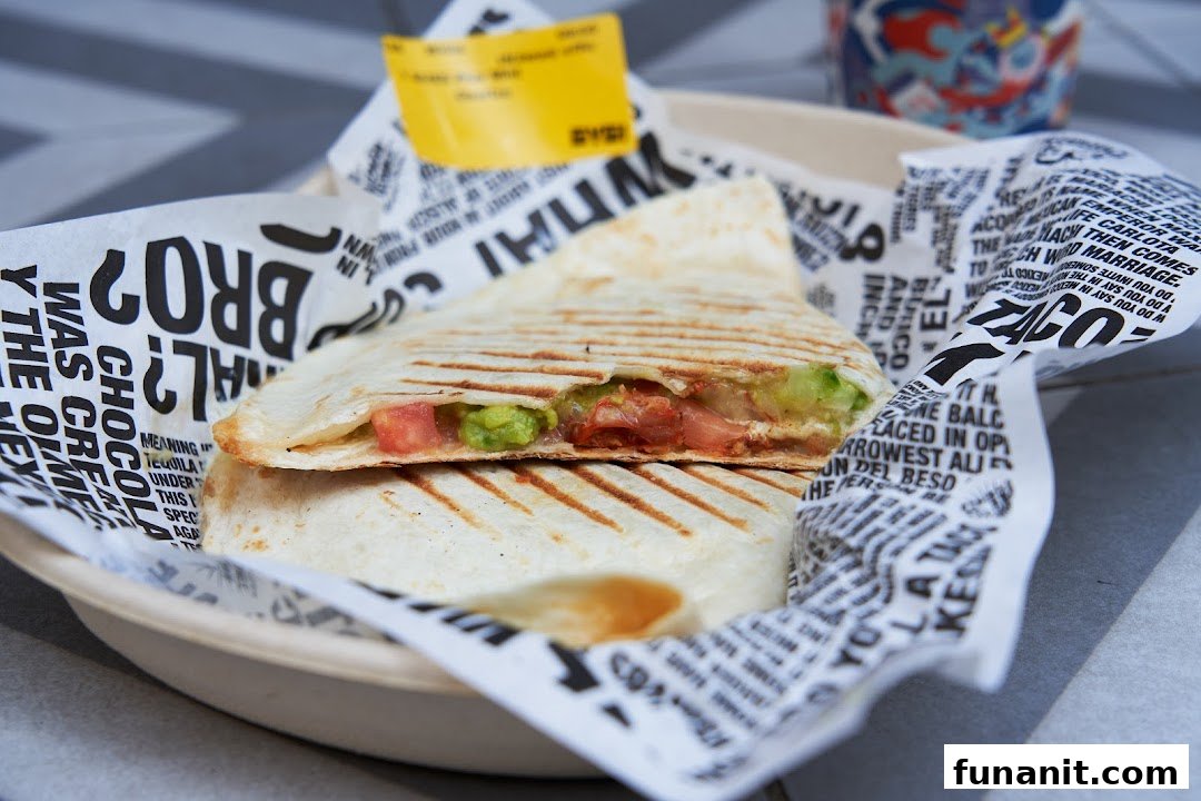 A close-up of a delicious quesadilla filled with fresh guacamole and tomatoes from Guzman y Gomez.