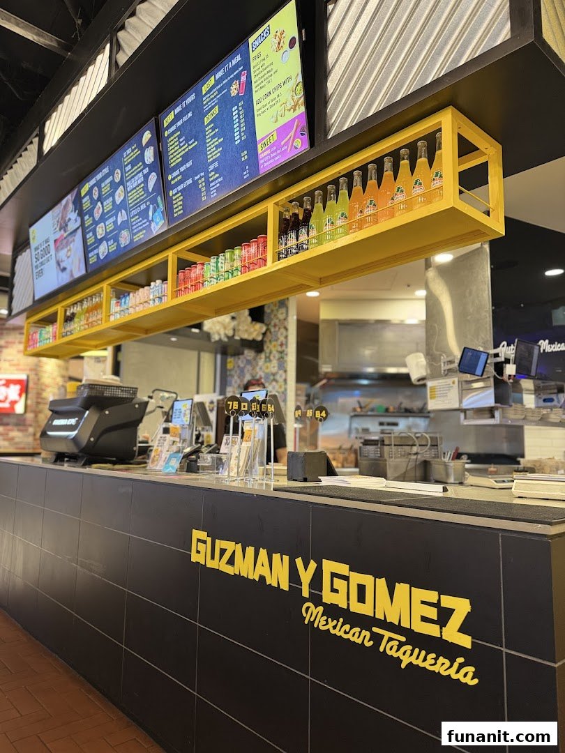 Digital menu boards displaying food and drink options at Guzman y Gomez.