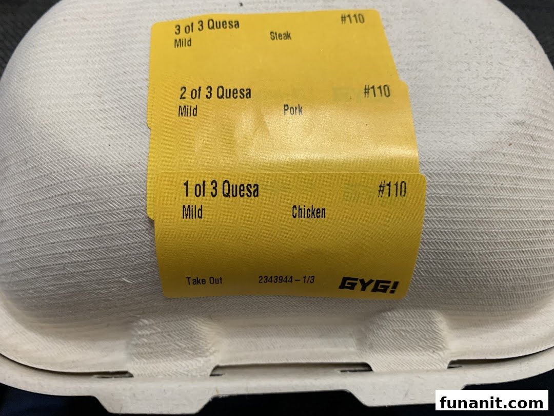 A close-up of a Guzman y Gomez takeaway container with order labels for quesadillas.