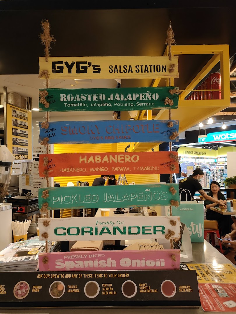 A vibrant display showcasing Guzman y Gomez's fresh salsa and topping station with various options.