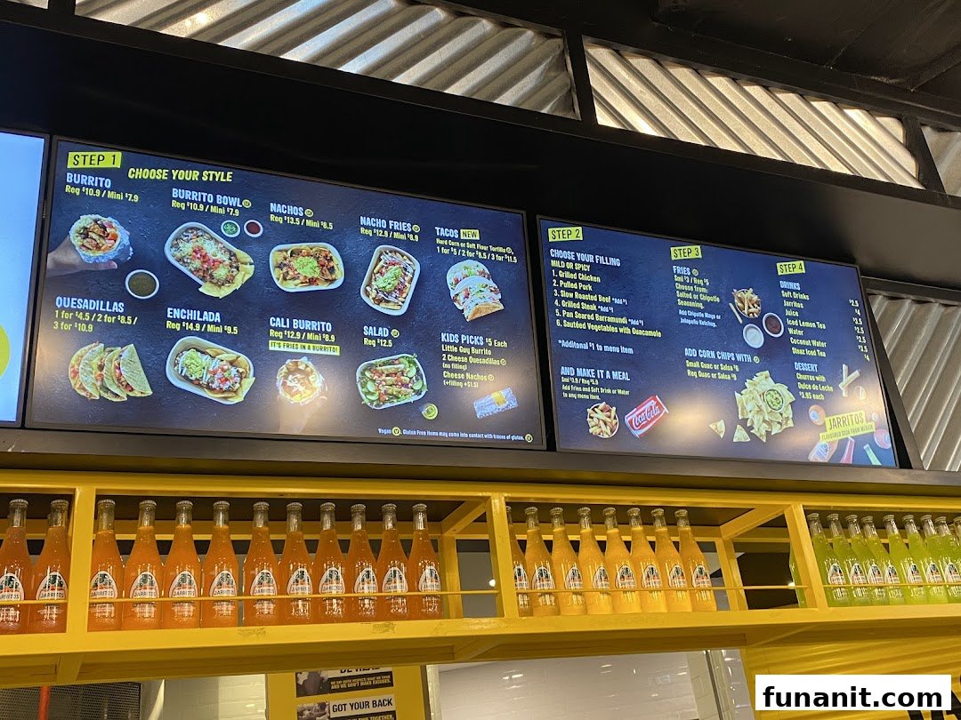 A digital menu board displaying various Mexican food options, drinks, and pricing at Guzman y Gomez.