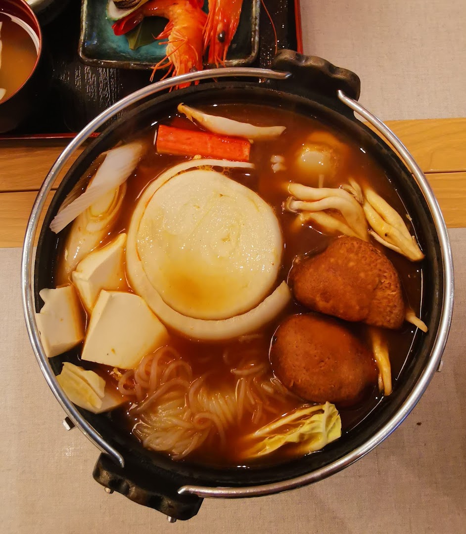 A close-up view of a simmering Japanese sukiyaki hot pot filled with various ingredients.