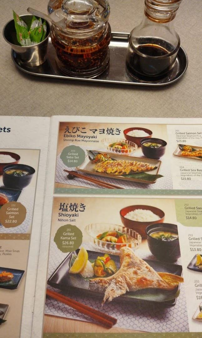 A close-up of a Japanese grilled fish and sukiyaki menu, featuring various set meals.