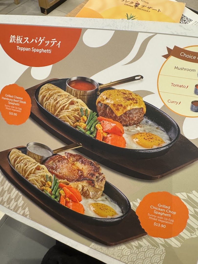 Two sizzling Teppan Spaghetti dishes with steak and chicken, served on hot plates.