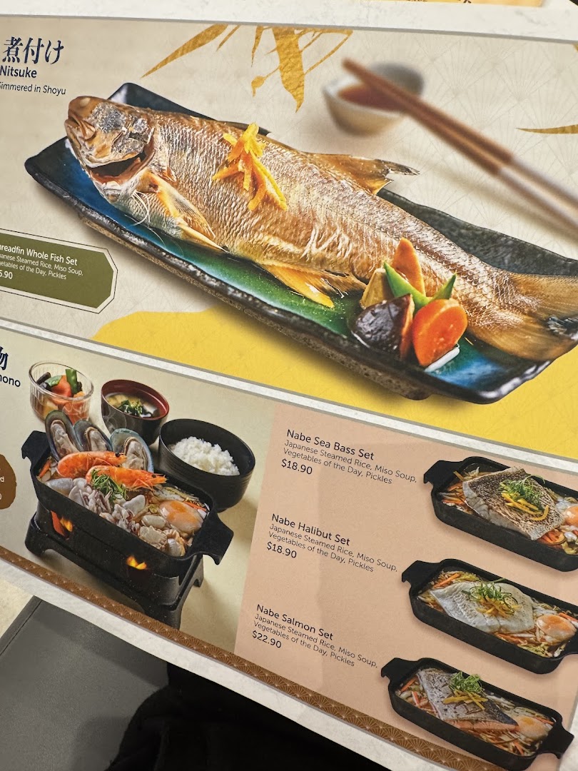 A close-up of a menu displaying various Japanese grilled fish and sukiyaki hot pot sets.