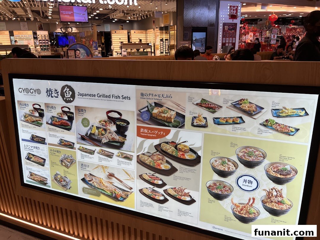 A brightly lit display menu board showcasing various Japanese grilled fish sets, donburi, and other dishes from GyoGyo.