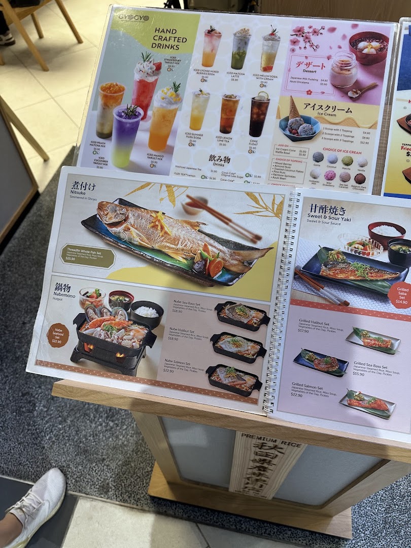 A detailed menu display showcasing various Japanese grilled fish sets, hotpots, handcrafted drinks, and desserts.