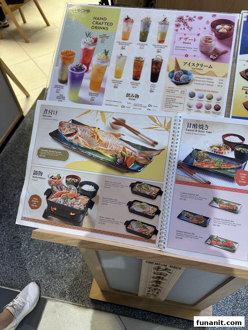 A detailed menu display showcasing various Japanese grilled fish sets, hotpots, handcrafted drinks, and desserts.