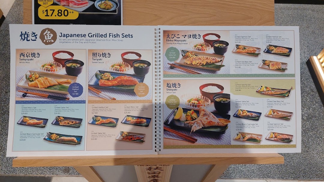 An open menu displaying various Japanese grilled fish sets and a beef set.