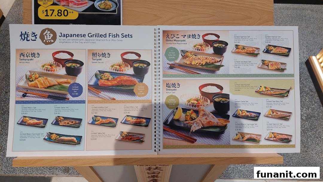 An open menu displaying various Japanese grilled fish sets and a beef set.