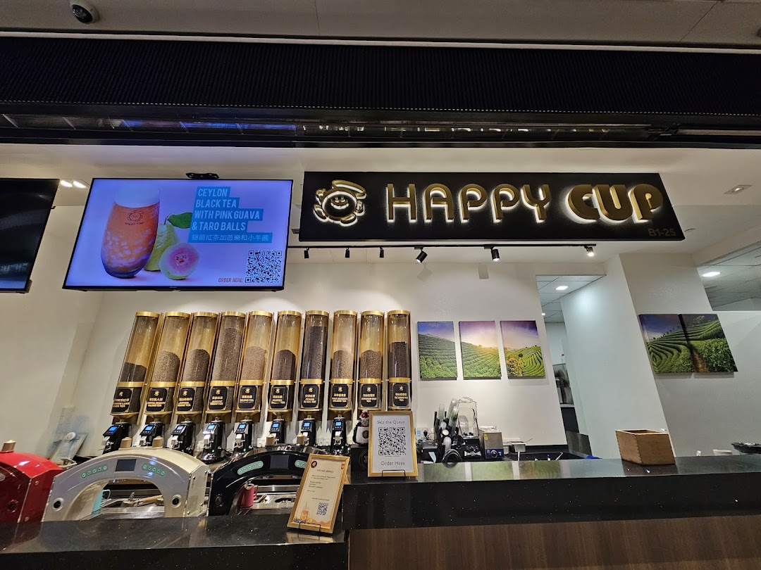 Interior view of Happy Cup Funan, showing tea dispensers, digital display, and shop counter.