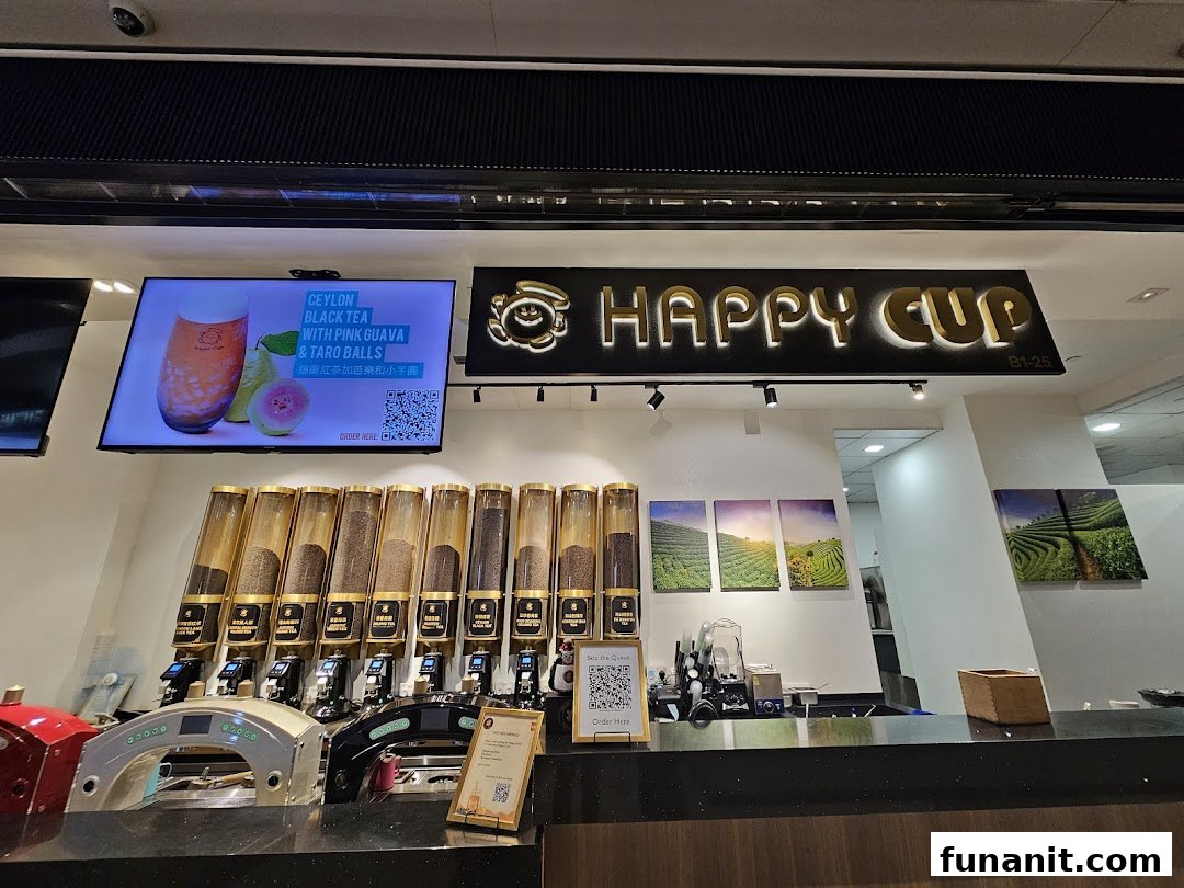 Interior view of Happy Cup Funan, showing tea dispensers, digital display, and shop counter.