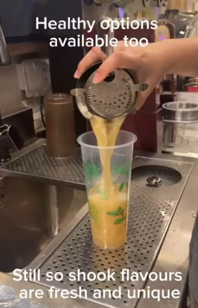 A barista pours a fresh, healthy drink into a cup at Happy Cup Funan, highlighting unique flavors.