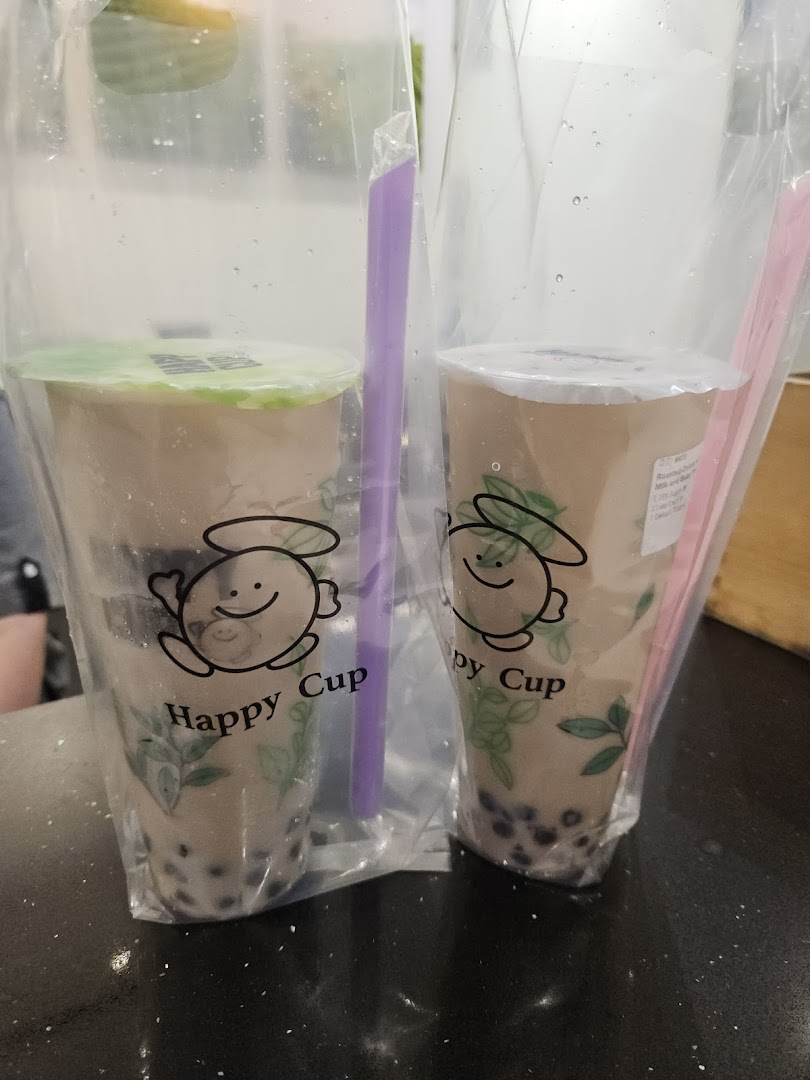Two bubble tea drinks from Happy Cup, served in clear plastic bags with straws.