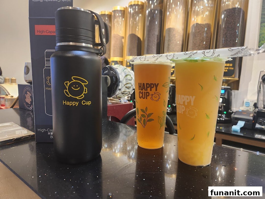 Two refreshing Happy Cup beverages and a branded reusable bottle displayed on a counter.