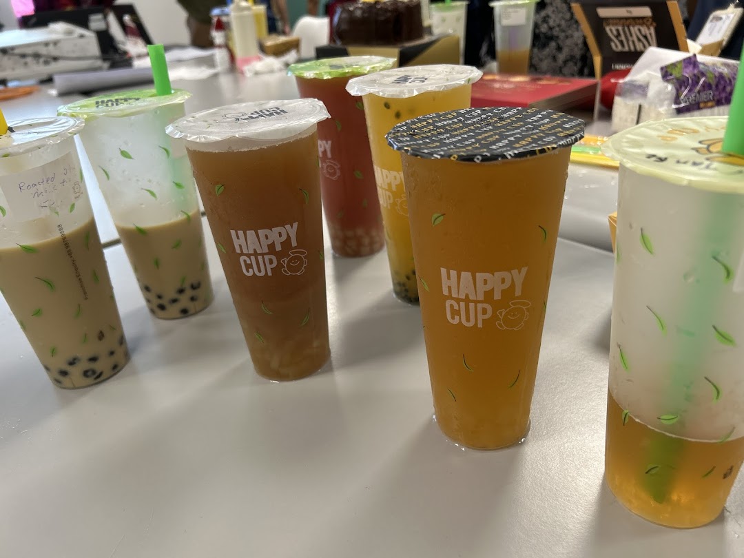 A vibrant display of various bubble tea drinks from Happy Cup, showcasing different colors and flavors.