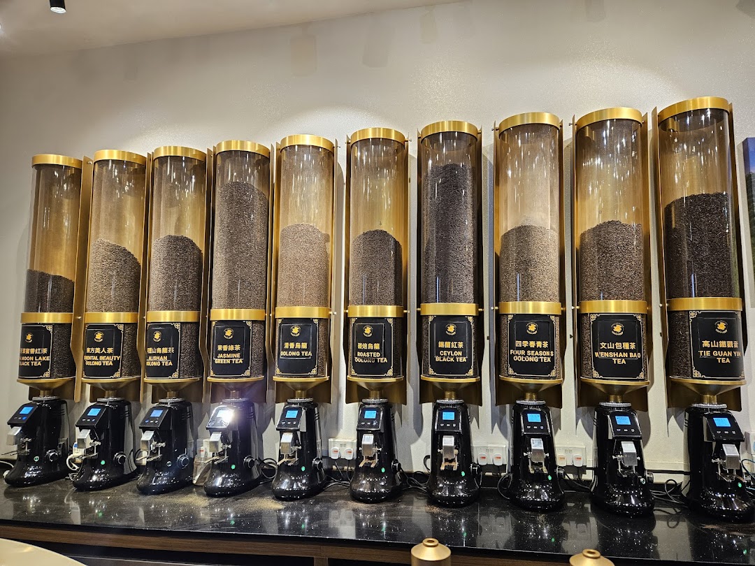 A display of various tea leaves in large dispensers with labels and dispensing machines.