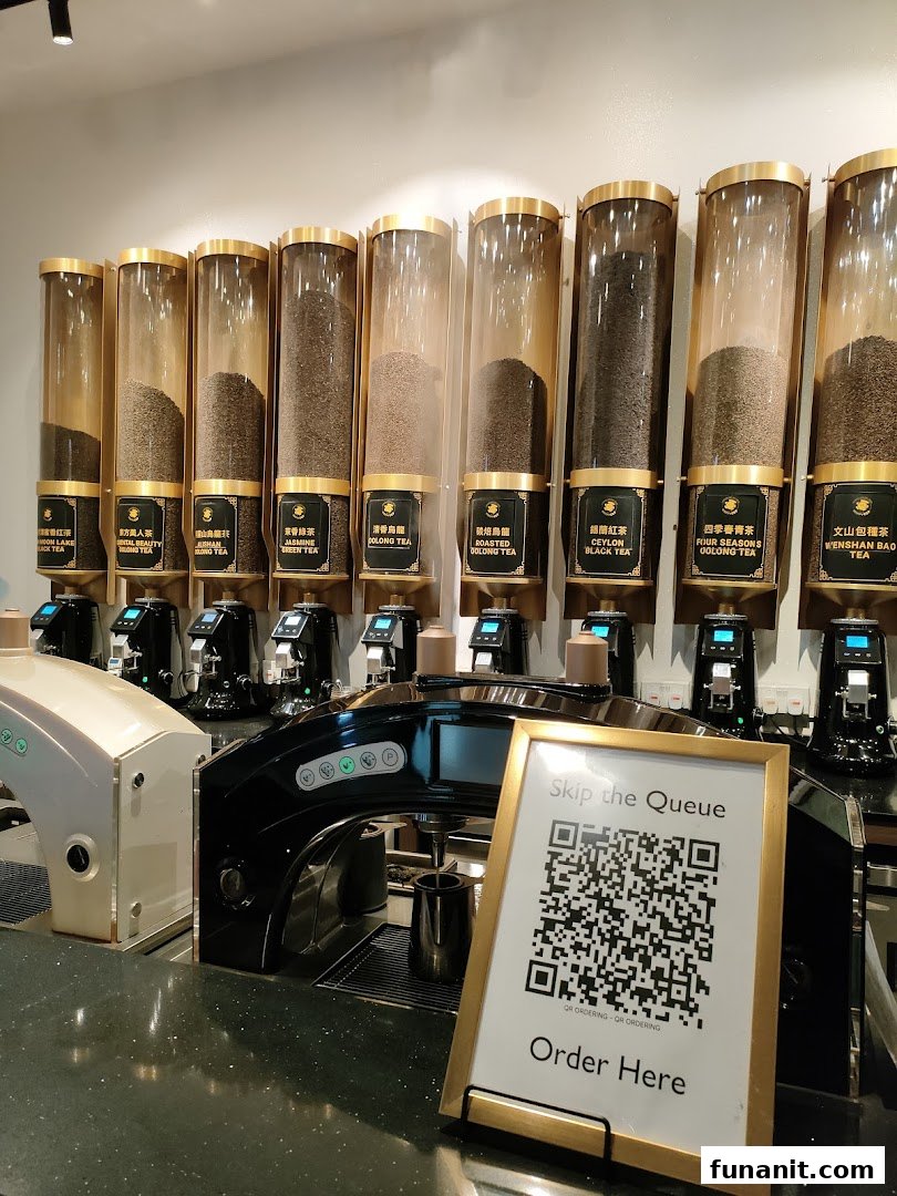 A display of various tea leaves in dispensers with brewing machines and a QR code for ordering.