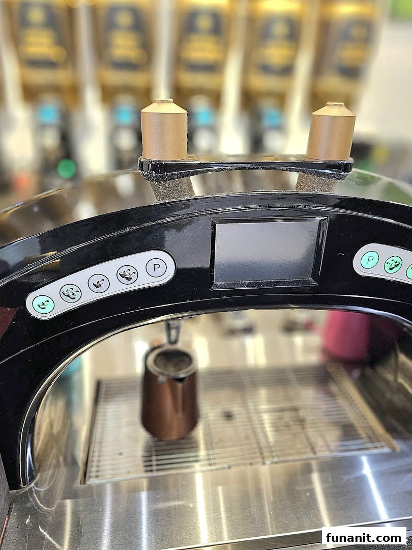 Close-up of a modern beverage dispensing machine with a small pitcher, ready to serve drinks.