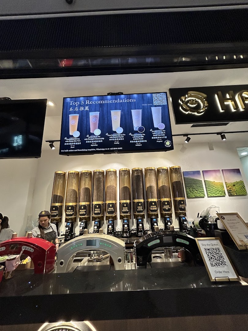 A digital display at Happy Cup Funan showcasing top 5 tea recommendations with images and descriptions.