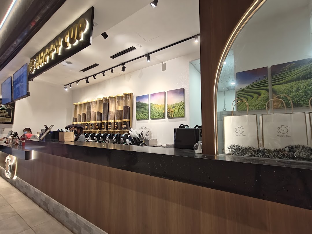 An interior view of Happy Cup Funan, featuring the service counter with ingredient dispensers and staff.