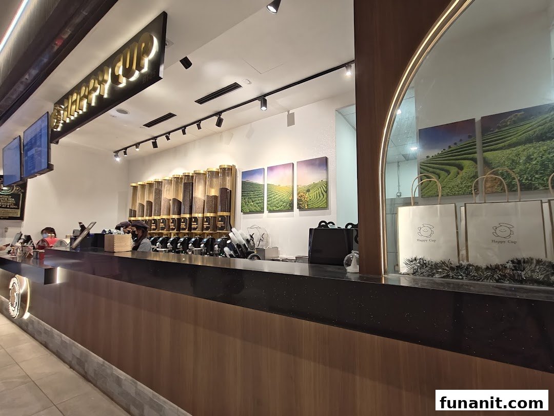 An interior view of Happy Cup Funan, featuring the service counter with ingredient dispensers and staff.