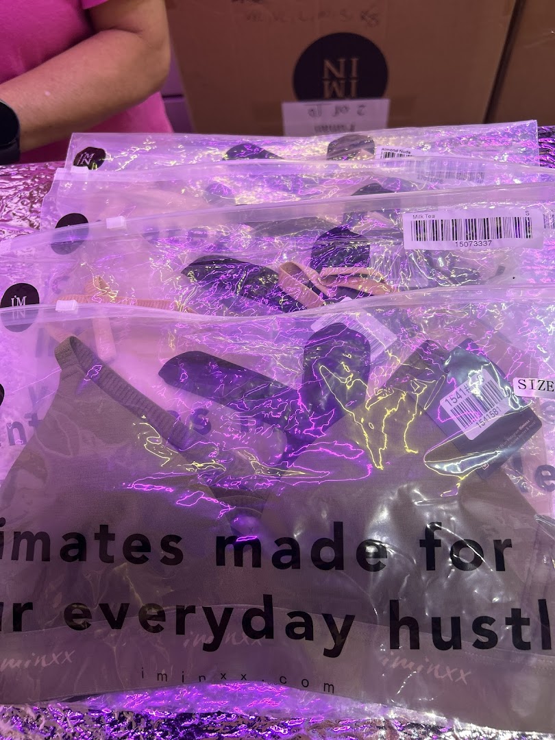Close-up of IM IN IMINXX packaged intimates, highlighting branding and product details under purple lighting.